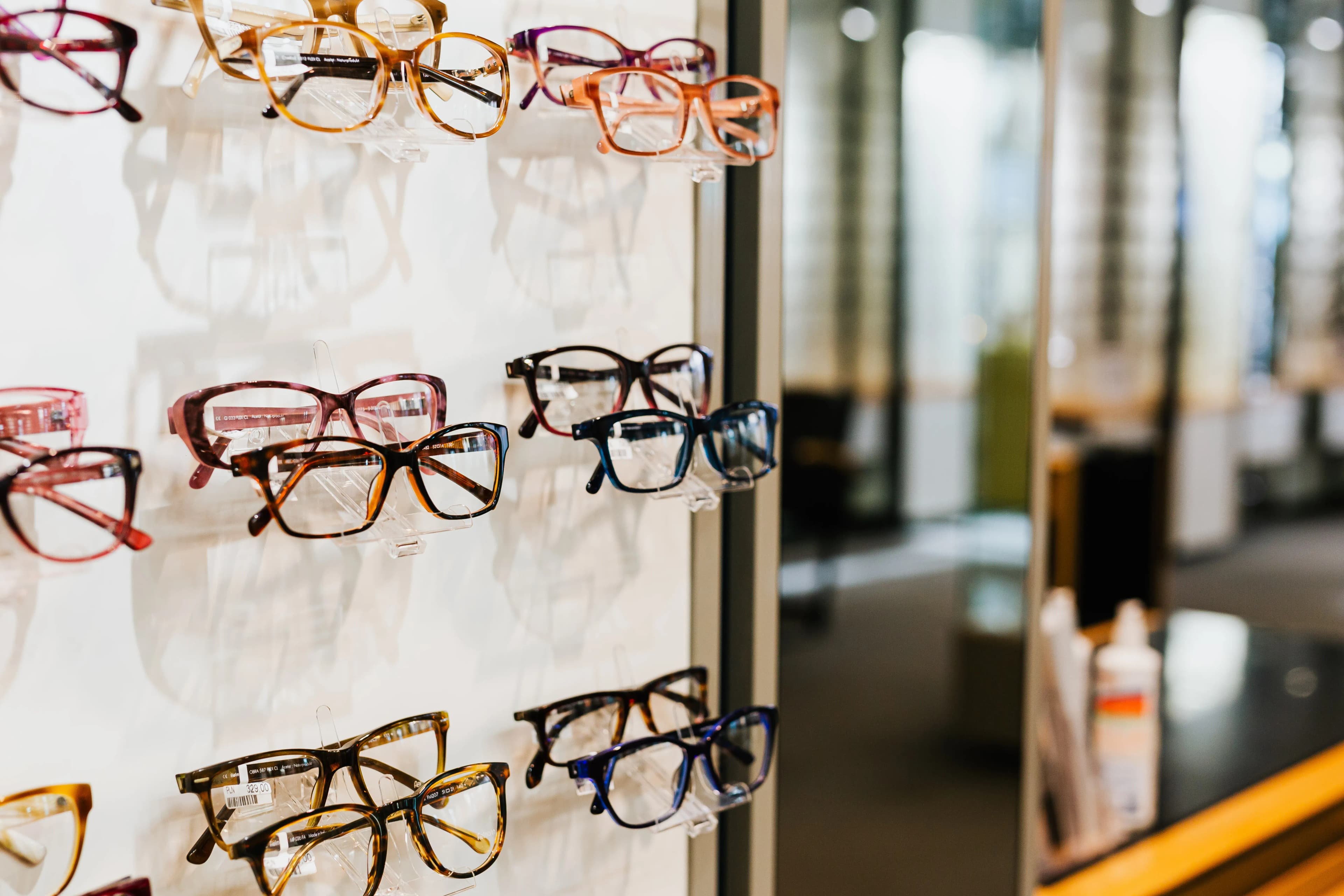 Eyeglasses arranged on a bright glass shelf
